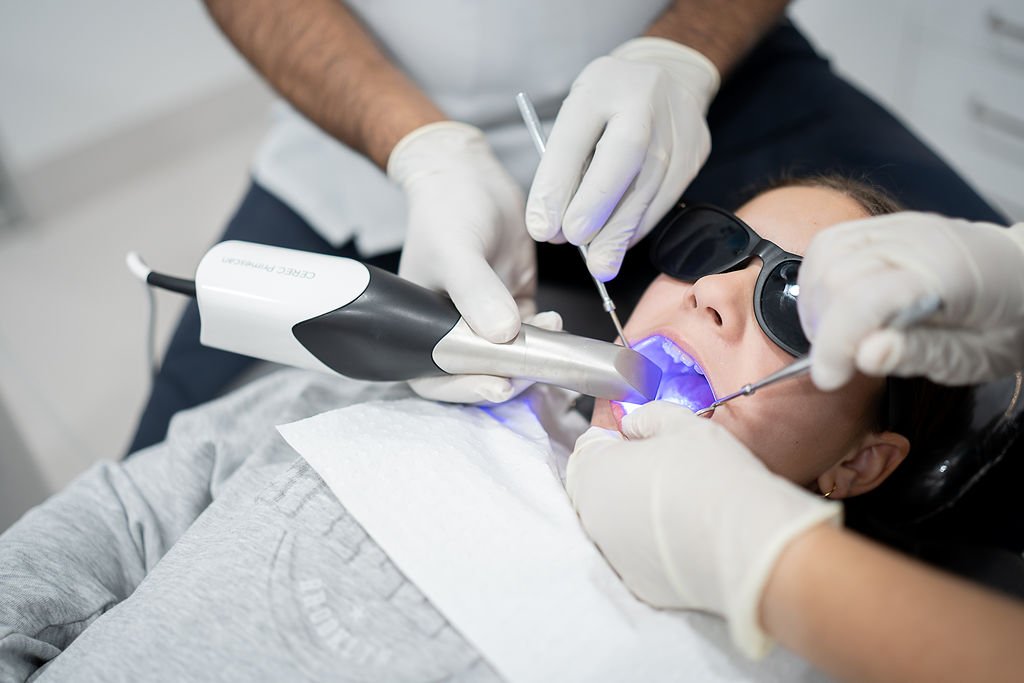 Dentist using a curing light to set a composite resin filling at Dentist at Underwood